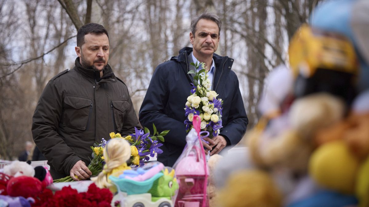 الرئيس الأوكراني زيلينسكي، يسار، ورئيس الوزراء اليوناني كيرياكوس ميتسوتاكيس يضعان الزهور في مكان الهجوم الروسي في منطقة سكنية في 2 مارس، في أوديسا، أوكرانيا، 6 مارس. 2024
