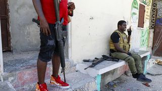 Barbecue, líder de la banda criminal "G9 y Familia" habla por teléfono tras dirigirse a los periodistas en un barrio de Puerto Príncipe, en Haití, el martes 5 de marzo de 2024