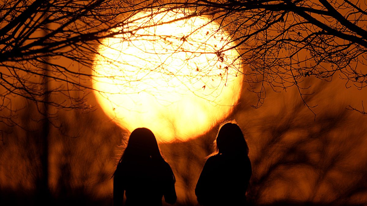 People watch the sunset at a park on an unseasonably warm day, Feb. 25, 2024, in Kansas City,- εικόνα αρχείου