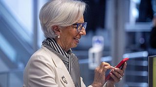President of European Central Bank, Christine Lagarde, holds a mobile device prior to a press conference after an ECB's governing council meeting in Frankfurt, Germany.