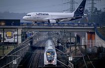 Frankfurt'ta bir demiryolu hattı üzerindeki bir köprüde ilerleyen bir Lufthansa uçağı