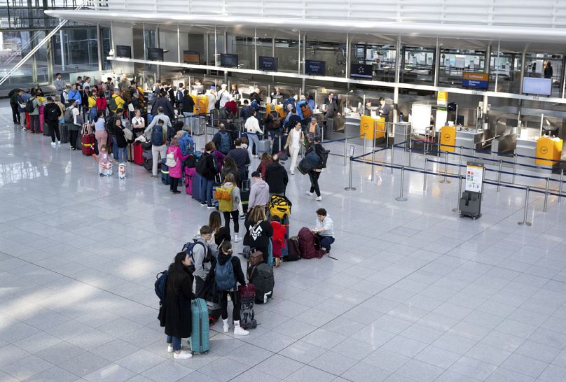 Passengers wait at a Lufthansa check-in counter at Munich Airport, Germany last Thursday