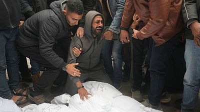 Palestinians mourn relatives killed in the Israeli bombardments of the Gaza Strip in front of the morgue of the Al Aqsa Hospital in Deir al Balah on March 7.