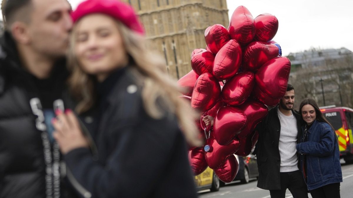 Couples pose for a photograph during the Valentine's Day in London, Wednesday, Feb. 14, 2024. 