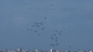 Parachutes drop supplies into the northern Gaza Strip, as seen from southern Israel, Thursday, March 7