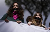 Las mujeres tienen cinta negra en la boca durante una marcha con motivo del Día Internacional de la Mujer, en Roma, el viernes 8 de marzo de 2024.