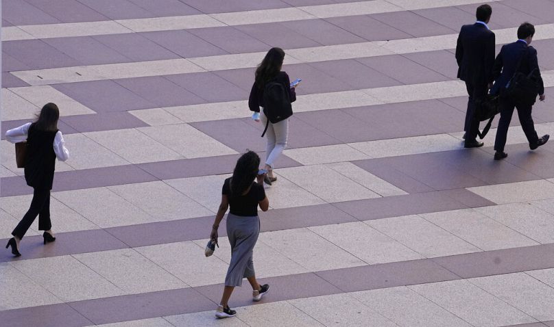Women walk towards an office building in Madrid, May 2022
