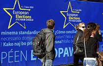 В кулуарах съезда Европейской народной партии, на фоне предвыборных плакатов 