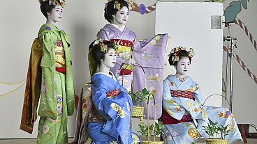 Maiko, or apprentice geiko, pose for photos ahead of the upcoming Gion Odori dance performance in Kyoto, western Japan