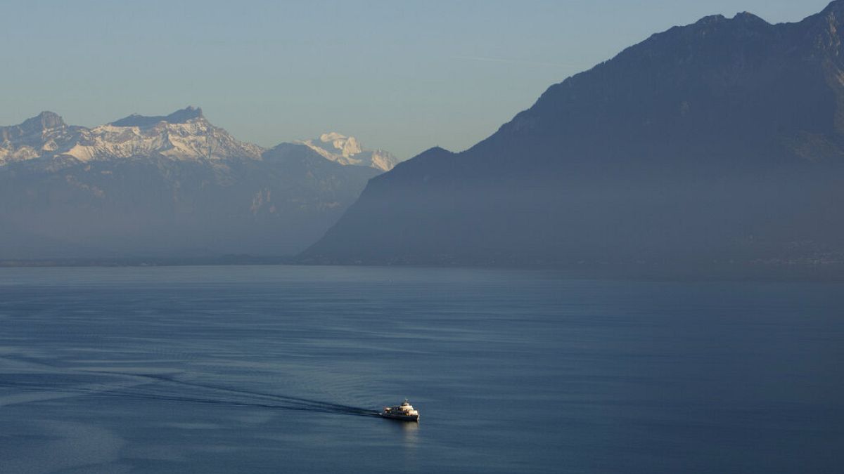 A passenger boat makes its way in Lake Geneva, backdropped by the Alps, as seen from Riex, 80 kilometers (50 miles) east of Geneva, Switzerland,