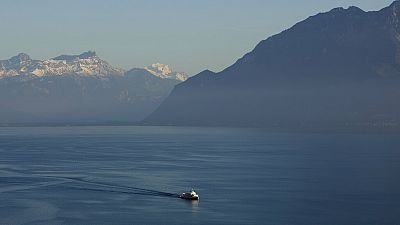 A passenger boat makes its way in Lake Geneva, backdropped by the Alps, as seen from Riex, 80 kilometers (50 miles) east of Geneva, Switzerland,