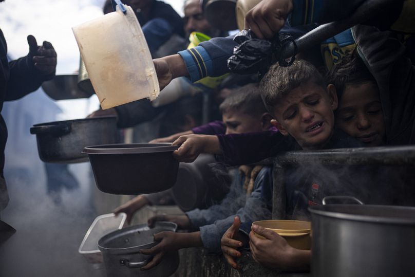 Gazze'de yemek almak için sırada bekleyen Filistinli çocuklar