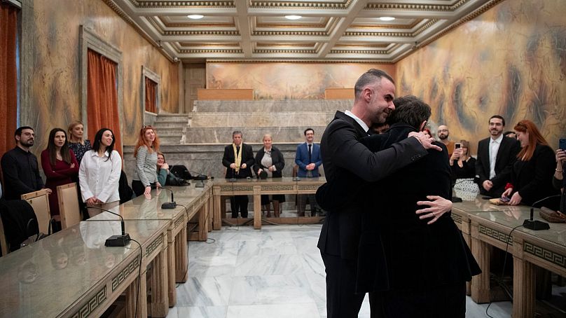 Lawyer Anastasios Samouilidis, left, hugs his husband, Greek author Petros Hadjopoulos, who uses the pen name Auguste Corteau, as guests watch, after their wedding in Athens.