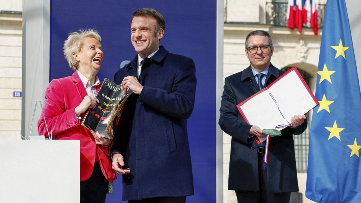La escritora Claudine Monteil, a la izquierda, y el presidente francés Emmanuel Macron asisten a la ceremonia para sellar el derecho al aborto en la Constitución francesa.