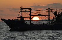 The sun rises while a suspected Chinese militia ship blocks Philippine coast guard ship, not shown, in the disputed South China Sea Tuesday, March 5, 2024.