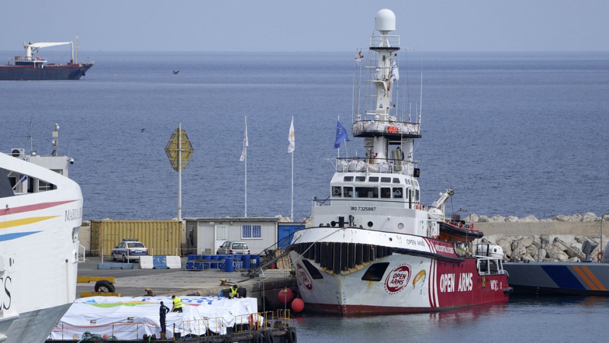 Empleados portuarios preparan la carga de ayuda en una plataforma cerca del barco perteneciente a la ONG Open Arms, amarrado en el puerto de Larnaca, Chipre.