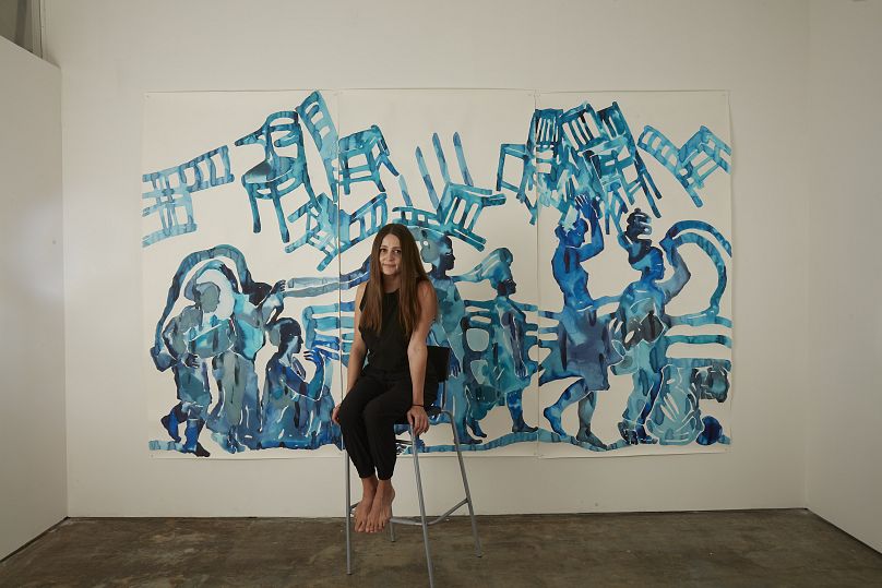 Katya Muromtseva poses with one of her artworks