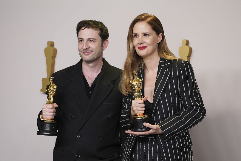 Arthur Harari and Justine Triet with their Oscars for Best Original Screenplay for Anatomy of a Fall