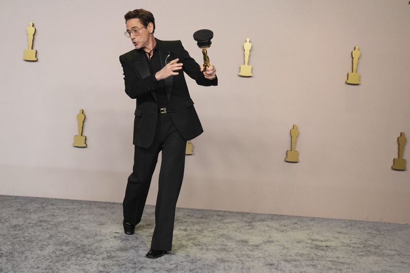 Robert Downey Jr. poses in the press room with the award for best performance by an actor in a supporting role for "Oppenheimer" at the Oscars