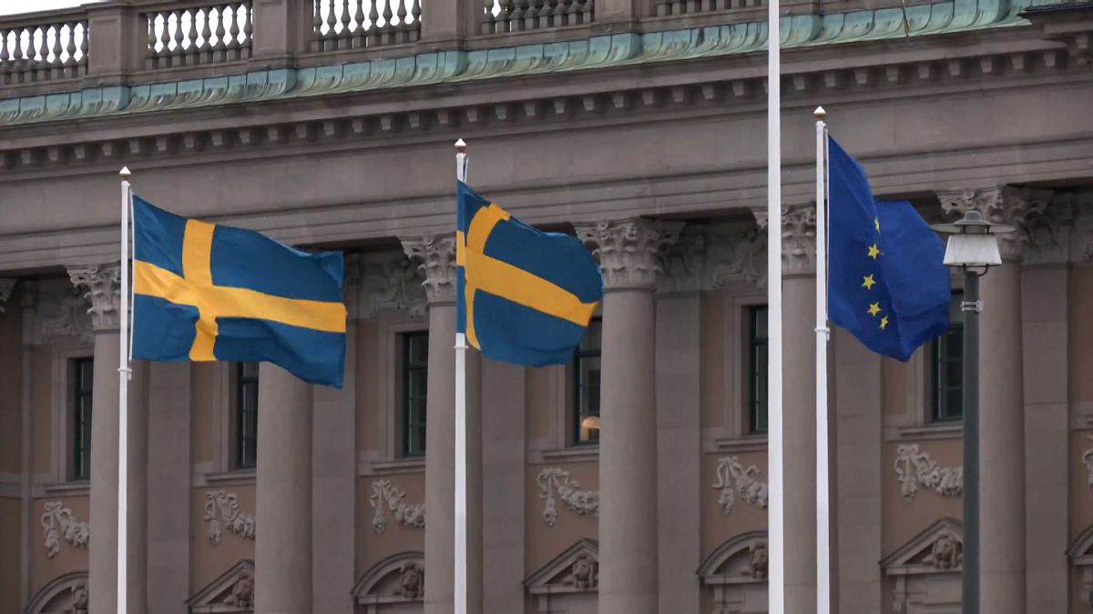 Bandeiras da Suécia e da União Europeia em frente ao Parlamento sueco em Estocolmo.