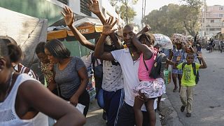 Lakosok menekülnek a rendőrség és a bandatag összecsapásai elől  Port-au-Prince-ben