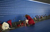 A woman lights a candle at a memorial to the victims of the train bombing inside the Atocha train station in Madrid, Spain, Monday, March 11, 2024.