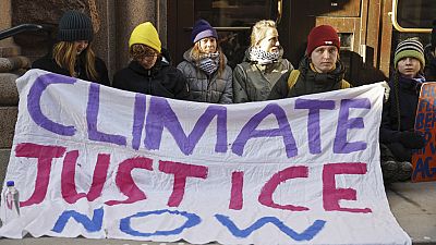 La activista climática Greta Thunberg, tercera por la izquierda, y otros manifestantes, bloquean la entrada del Parlamento sueco durante una protesta en Estocolmo.