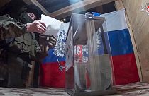 Un militaire russe dans un bureau de vote improvisé lors du vote anticipé des élections présidentielles russes dans la région de Donetsk contrôlée par la Russie.