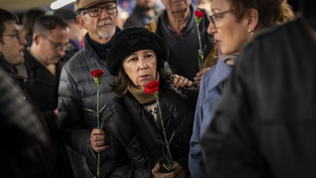Ciudadanos hacen cola para depositar flores en un monumento a las víctimas del atentado al tren de 2004 dentro de la estación de tren de Atocha en Madrid