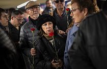 Ciudadanos hacen cola para depositar flores en un monumento a las víctimas del atentado al tren de 2004 dentro de la estación de tren de Atocha en Madrid