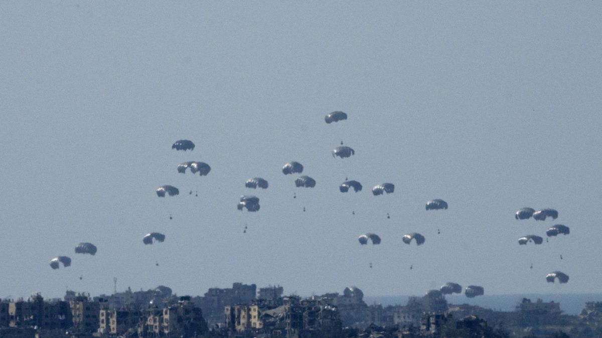 Parachutes drop humanitarian aid into the northern Gaza Strip, as seen from southern Israel, Monday, March 11, 2024. 