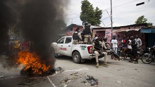 ضباط الشرطة الوطنية يمرون بإطارات مشتعلة خلال مظاهرة تطالب باستقالة رئيس هايتي