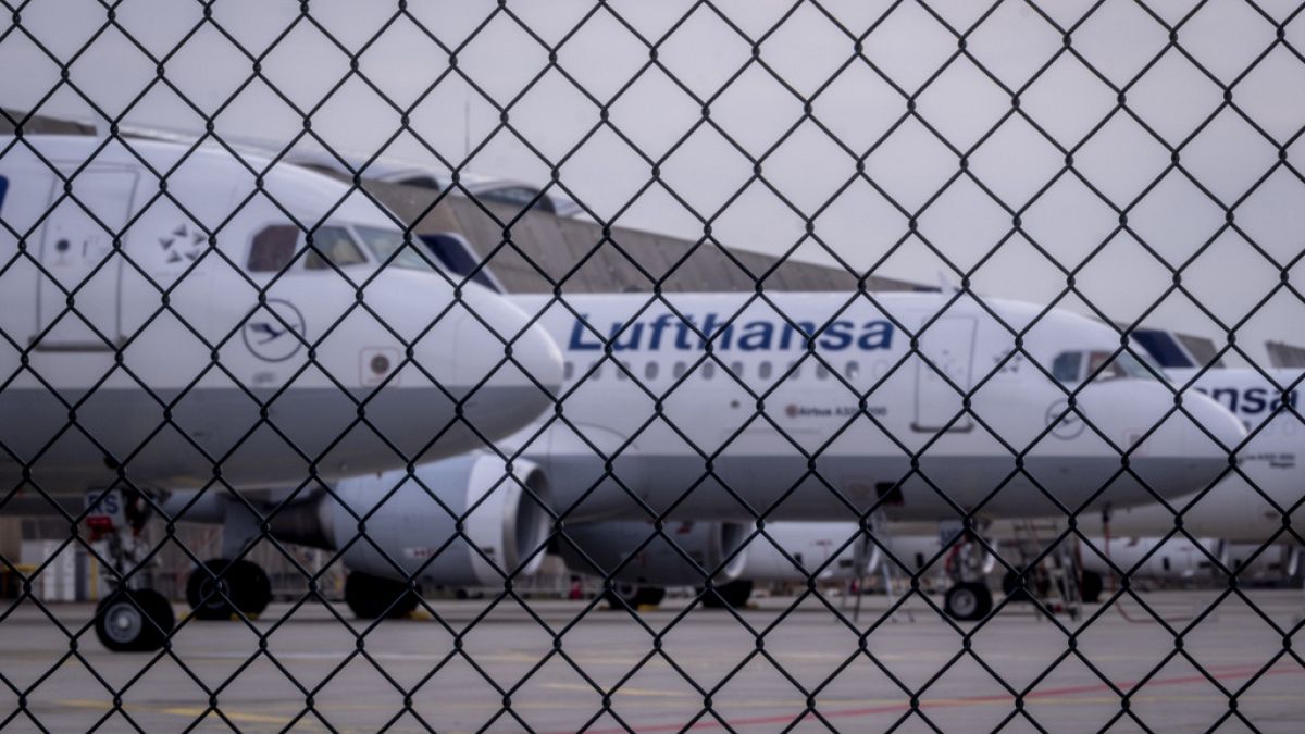 Lufthansa aircrafts are parked behind a fence at the airport in Frankfurt, Germany, Tuesday, 12 March, 2024.