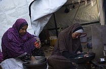 Two Palestinian women prepare food. 