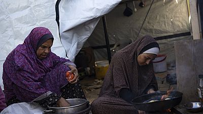 Two Palestinian women prepare food. 