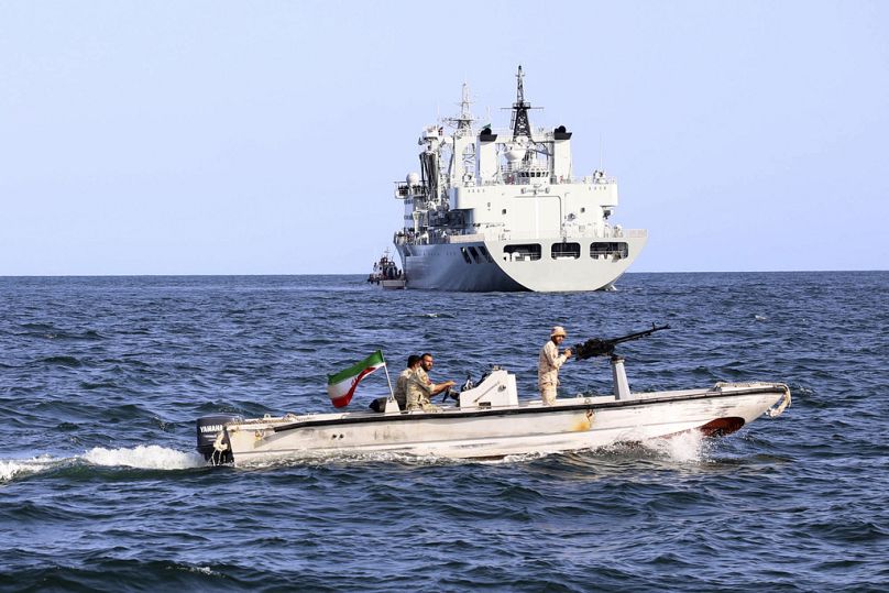 An Iranian military boat patrols as a warship enters the Iranian waters prior to start of a joint naval drill of Iran, Russia and China in the Indian Ocean.