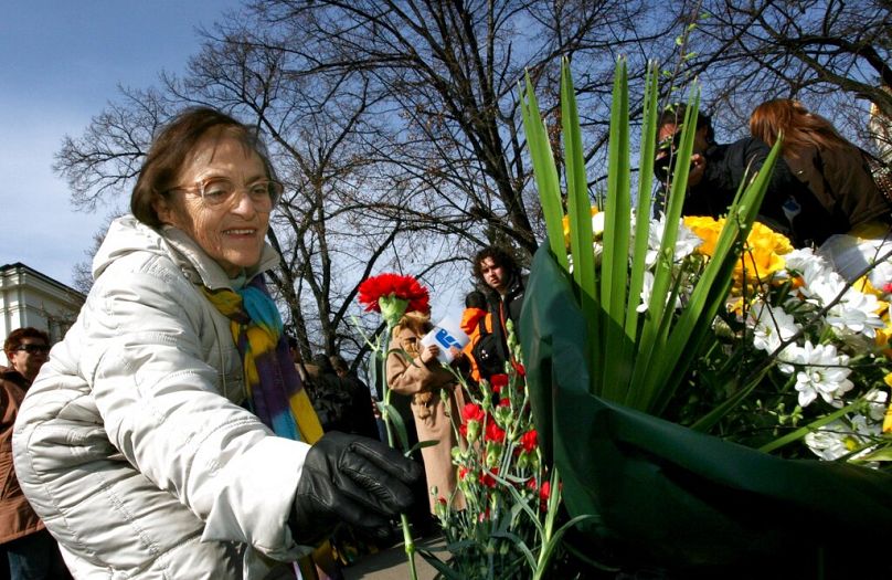 A woman puts a flower tribute at the memorial monument Sofia, to mark the rescue of Bulgarian Jews from Nazi death camps, March 2007