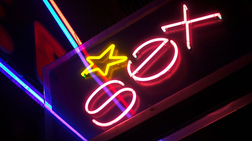 A close up shot of a neon sign that says sex