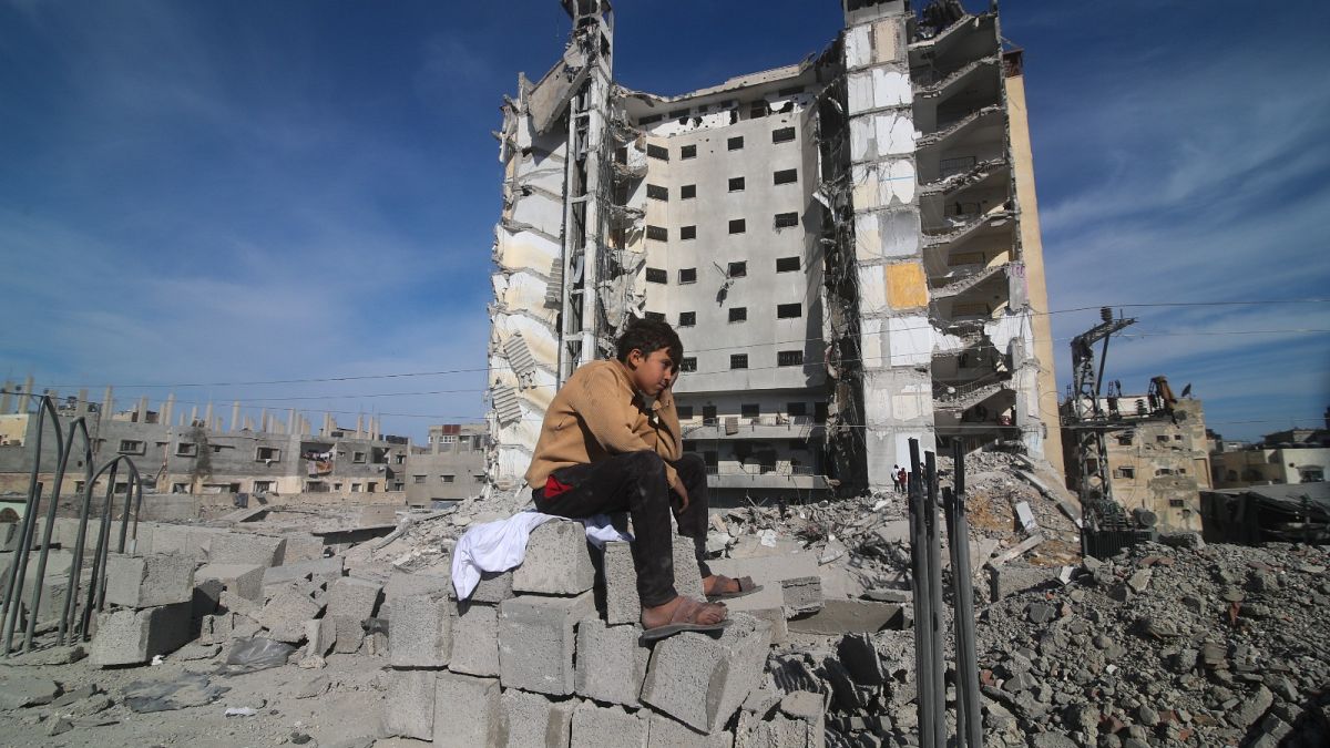 Un garçon palestinien est assis devant un immeuble résidentiel détruit par une frappe israélienne à Rafah, dans la bande de Gaza, le samedi 9 mars 2024. 