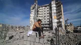 Un garçon palestinien est assis devant un immeuble résidentiel détruit par une frappe israélienne à Rafah, dans la bande de Gaza, le samedi 9 mars 2024. 