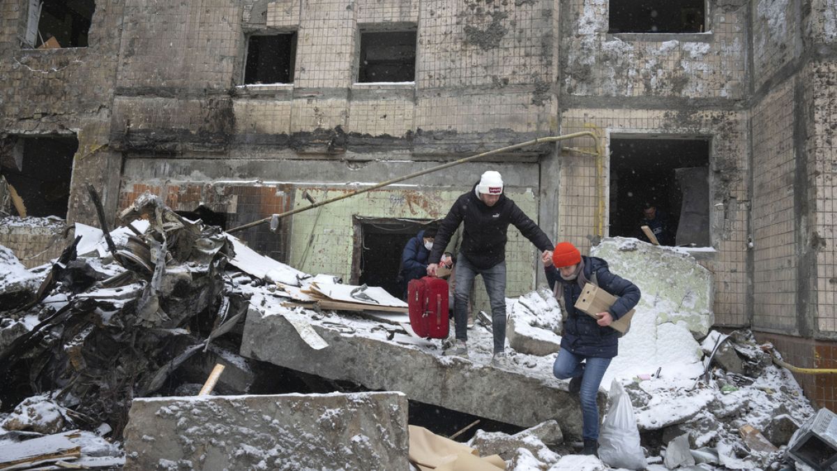 Egy pár a romok közül menti megmaradt ingóságait