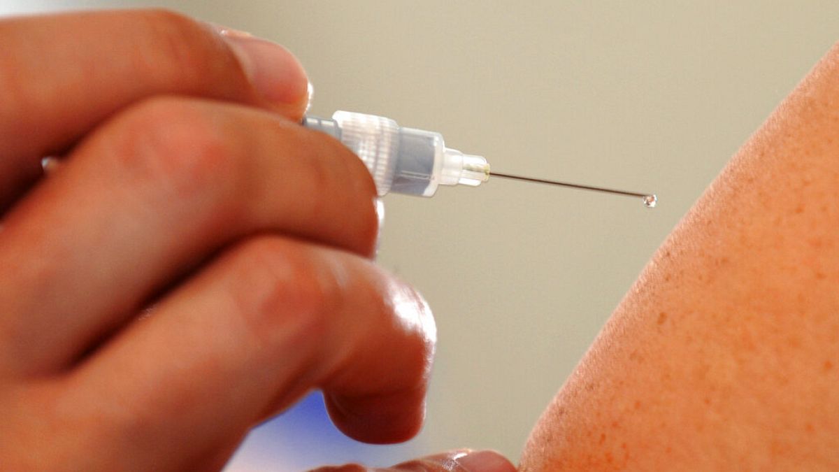 ARQUIVO - Um médico injecta uma vacina contra a gripe num paciente em Dresden, a 10 de outubro de 2008.