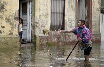 Un residente cerca di sturare un tombino in una strada allagata dopo una forte pioggia ad Avellaneda, alla periferia di Buenos Aires, Argentina, 12 marzo 2024
