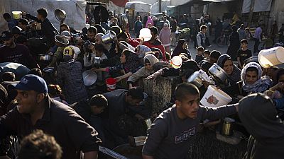 Palestinians line up for a free meal in Rafah, Gaza Strip, on Tuesday, March 12, 2024