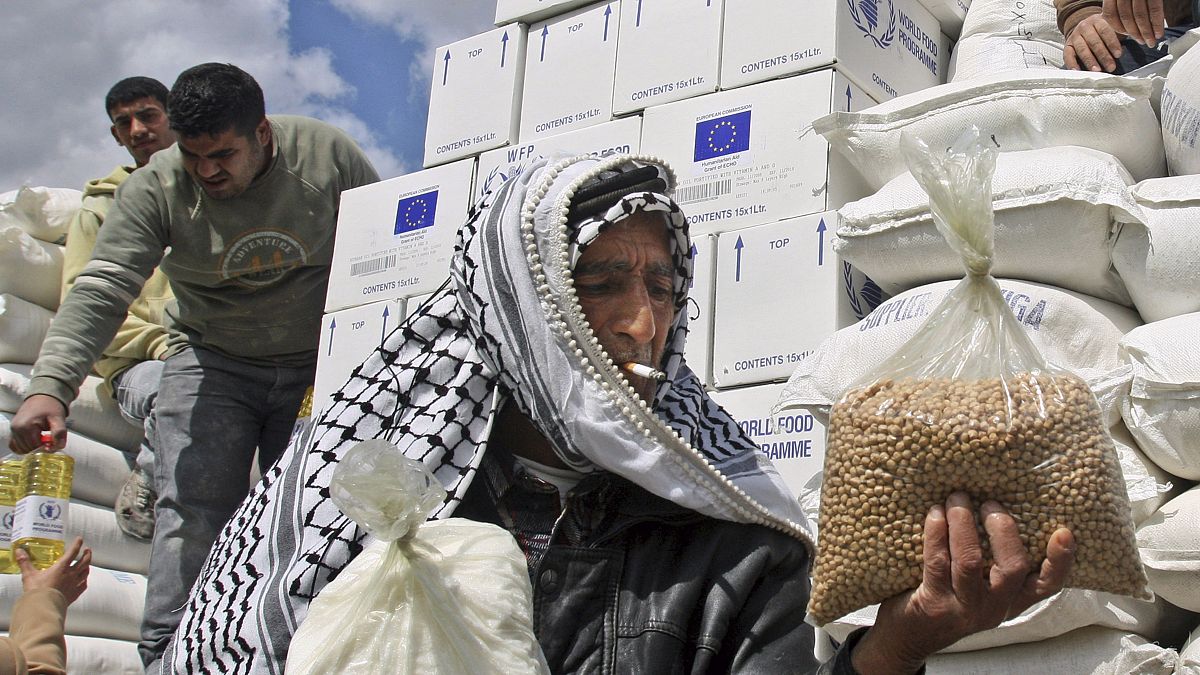 فلسطينيون يتلقون مساعدات غذائية خارج مركز توزيع الغذاء التابع للأمم المتحدة في قرية الزبابدة بالضفة الغربية