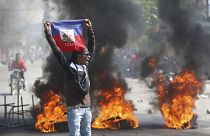 متظاهر يحمل علم هايتي خلال الاحتجاجات المطالبة باستقالة رئيس الوزراء أرييل هنري في بورت أو برنس