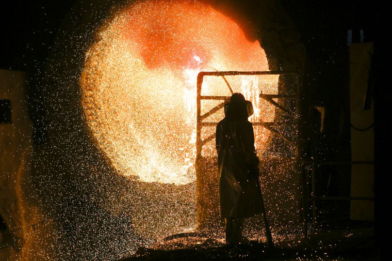 An employee in protective clothing works with a steel pouring ladle at a steel mill in Salzgitter, March 2019