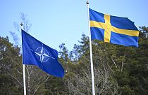 The NATO flag, left, is raised next to the Swedish flag during a ceremony at the Musko navy base Stockholm, Monday, March 11, 2024. 