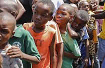 Kinder stellen sich in einer Unterkunft für von Bandengewalt vertriebene Familien in Port-au-Prince, Haiti, am Donnerstag, dem 14. März 2024, an, um Essen zu erhalten.