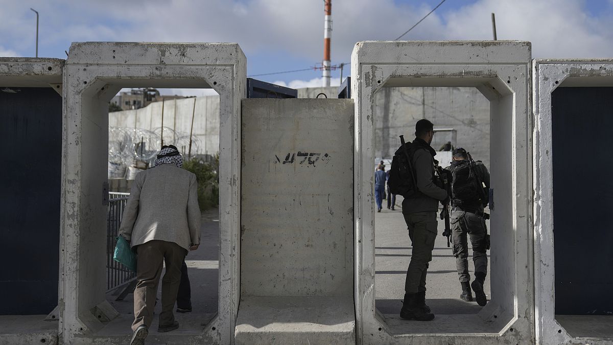فلسطينيون يعبرون من حاجز قلنديا العسكري الإسرائيلي بالقرب من مدينة رام الله بالضفة الغربية المحتلة إلى القدس. 2024/03/15